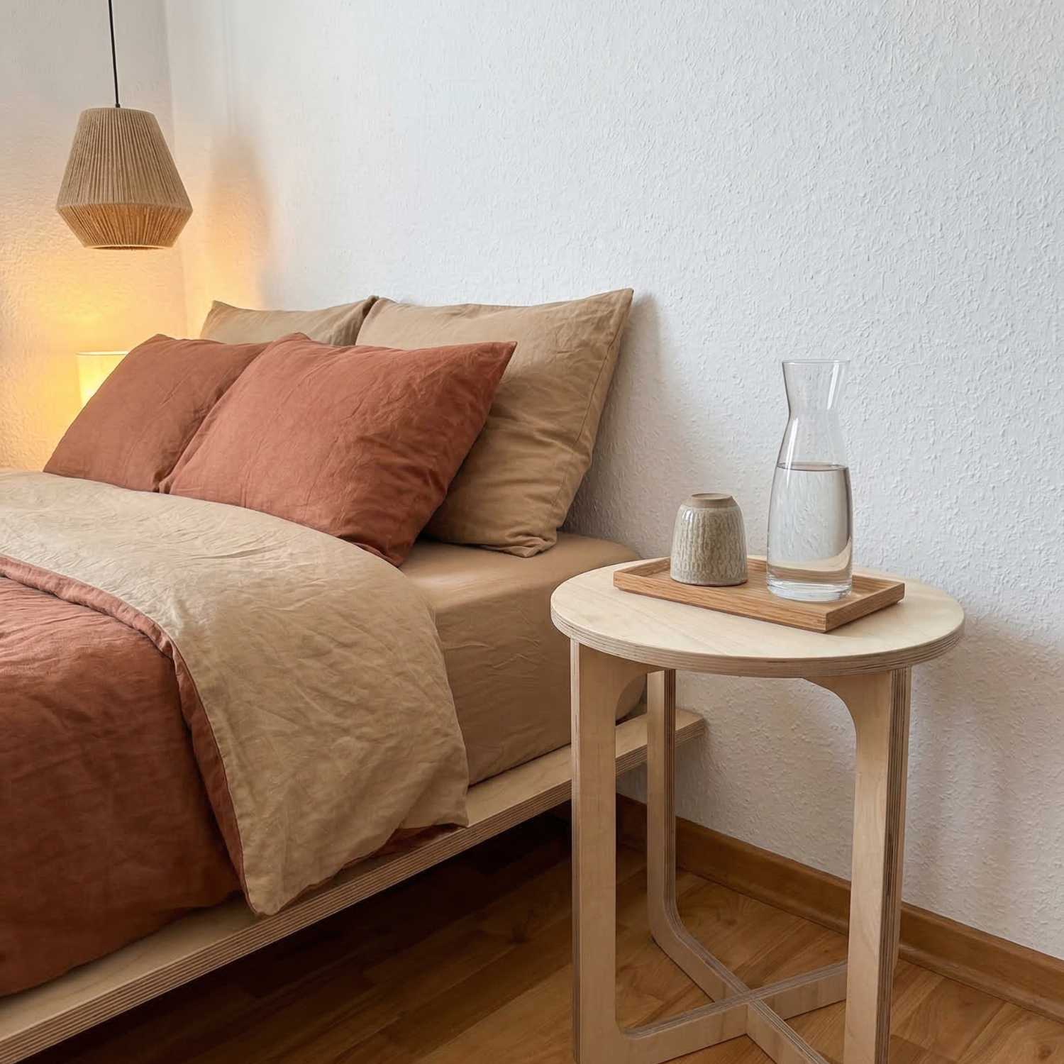 MUTAO Beistelltisch V1 als Nachttisch mit Wasserkaraffe neben Terrakotta-Leinenbett